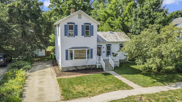 416 Kent St, Lowell, MI 49331 - traditional home with driveway, a front yard, and a chimney