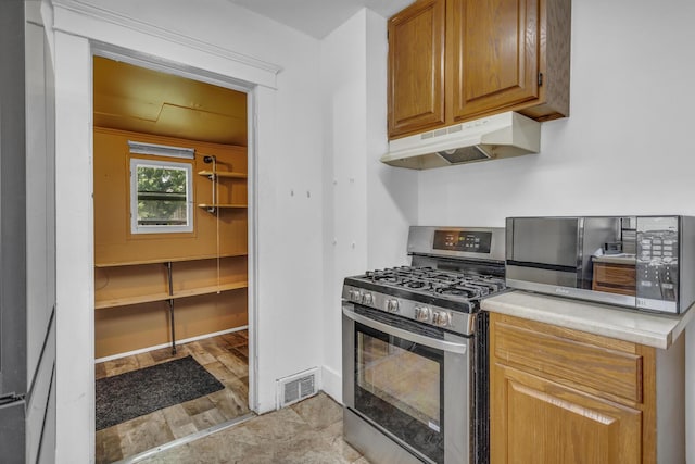 843 Center St, Jackson, MI 49202 - kitchen featuring appliances with stainless steel finishes, under cabinet range hood, and light countertops