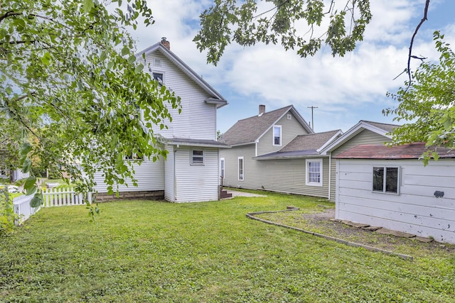 843 Center St, Jackson, MI 49202 - rear view of house featuring a lawn
