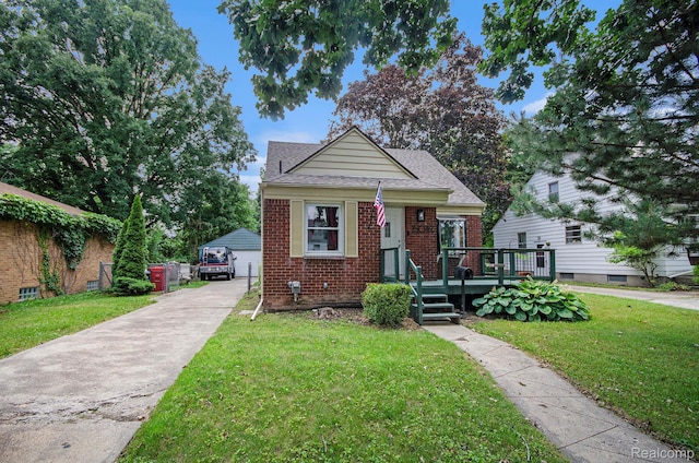 15042 Charles R Ave, Eastpointe, MI 48021 - bungalow-style home featuring brick siding, an outdoor structure, a front yard, a garage, and a shingled roof