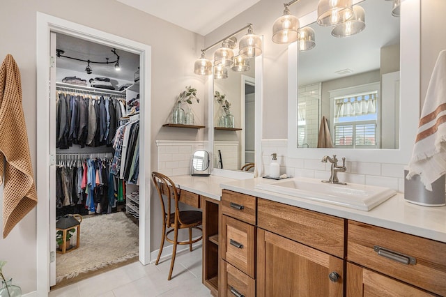 8608 52nd St SE, Ada, MI 49301 - bathroom with vanity, tile patterned flooring, a walk in closet, and tasteful backsplash