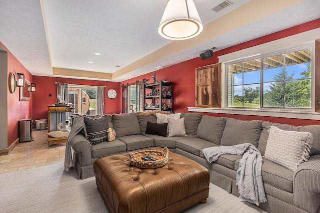 8608 52nd St SE, Ada, MI 49301 - living area with a raised ceiling, stone tile flooring, and recessed lighting