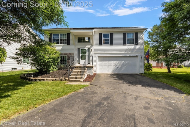 2601 Eardman Ct, Westland, MI 48186 - raised ranch featuring an attached garage, asphalt driveway, a front yard, and stone siding