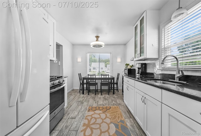 2216 Barrett Ave, Royal Oak, MI 48067 - kitchen with freestanding refrigerator, stainless steel gas range, white cabinetry, and glass insert cabinets