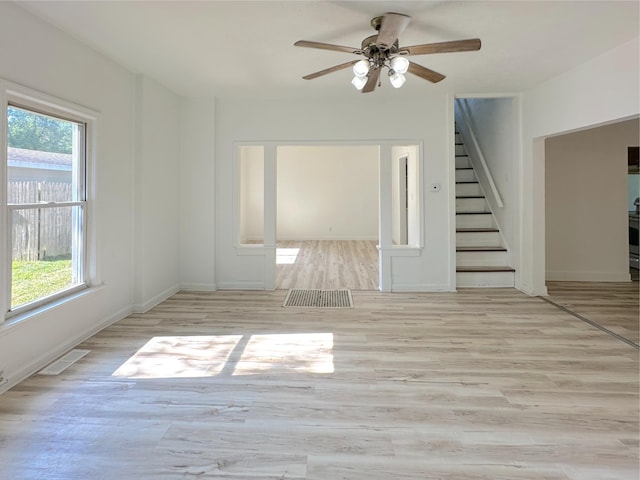 1006 Madison St, Three Rivers, MI 49093 - empty room featuring stairs, plenty of natural light, ceiling fan, and wood finished floors