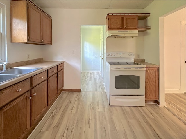 1006 Madison St, Three Rivers, MI 49093 - kitchen featuring white electric range oven, under cabinet range hood, brown cabinetry, and light wood-style flooring