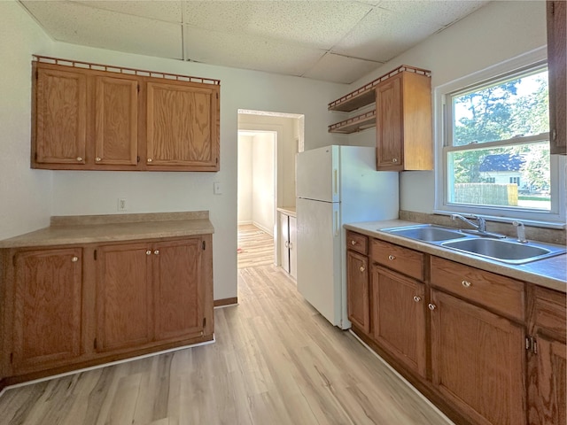 1006 Madison St, Three Rivers, MI 49093 - kitchen featuring freestanding refrigerator, a paneled ceiling, light wood-style flooring, brown cabinetry, and light countertops