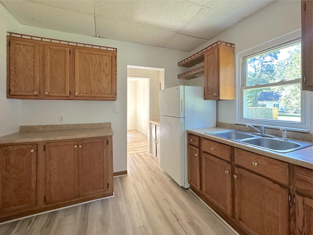 1006 Madison St, Three Rivers, MI 49093 - kitchen featuring a paneled ceiling, brown cabinets, light wood-style floors, and light countertops
