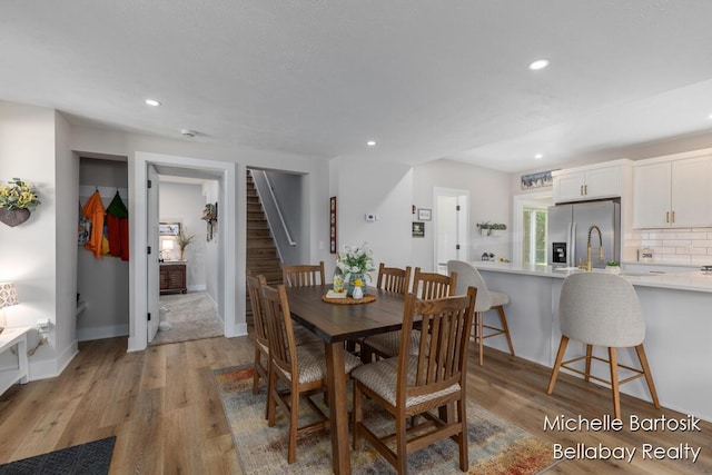 10840 Harvard Ave NE, Rockford, MI 49341 - dining area featuring stairs, light wood-style flooring, and recessed lighting