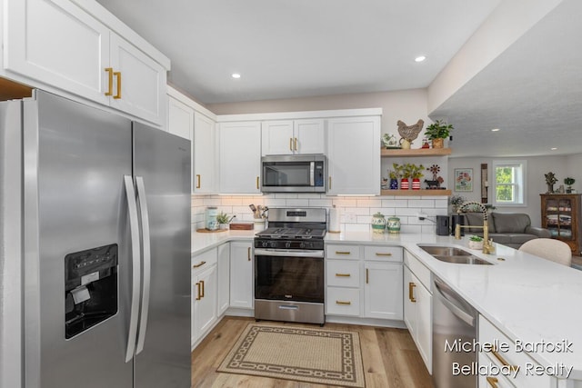 10840 Harvard Ave NE, Rockford, MI 49341 - kitchen with stainless steel appliances, light countertops, light wood-style flooring, white cabinets, and recessed lighting