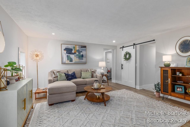 10840 Harvard Ave NE, Rockford, MI 49341 - living area featuring wood finished floors, a barn door, and recessed lighting