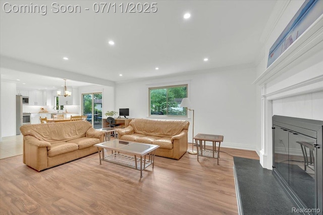 3417 Palm Aire Ct, Rochester Hills, MI 48309 - living area featuring light wood-style floors, recessed lighting, a glass covered fireplace, and crown molding