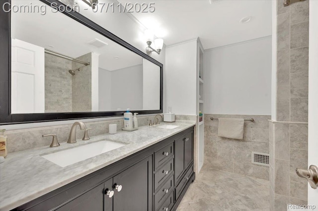 3417 Palm Aire Ct, Rochester Hills, MI 48309 - bathroom featuring double vanity, tile walls, a tile shower, and wainscoting