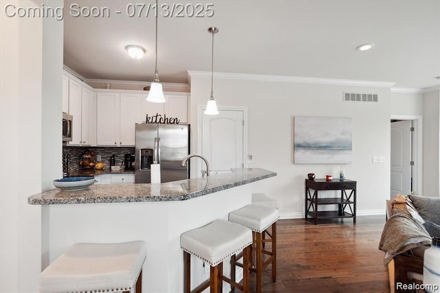 42384 Gateway Dr, Plymouth, MI 48170 - kitchen featuring stainless steel appliances, crown molding, dark wood-style flooring, white cabinetry, and stone countertops