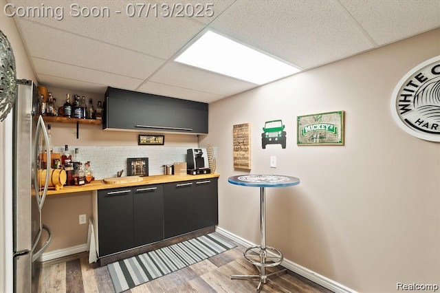 42384 Gateway Dr, Plymouth, MI 48170 - indoor wet bar featuring a paneled ceiling, freestanding refrigerator, wood finished floors, and tasteful backsplash