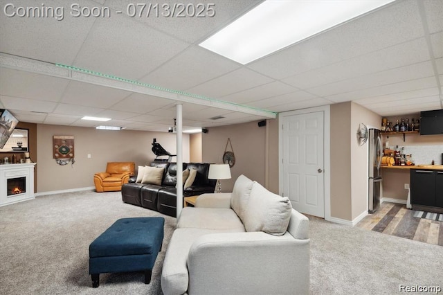 42384 Gateway Dr, Plymouth, MI 48170 - living area featuring light colored carpet, bar, a paneled ceiling, and a lit fireplace