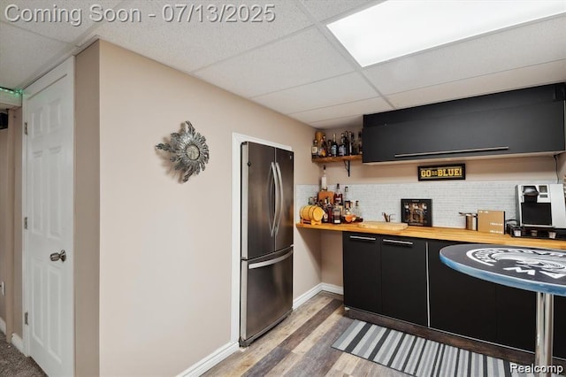 42384 Gateway Dr, Plymouth, MI 48170 - kitchen with freestanding refrigerator, butcher block countertops, a paneled ceiling, dark cabinetry, and light wood-type flooring