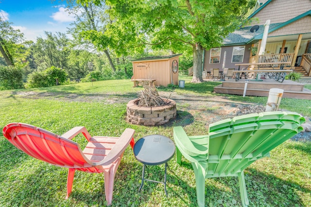 76 Meceola Ct, Hersey, MI 49639 - view of grassy yard featuring a shed, an outdoor fire pit, and a wooden deck