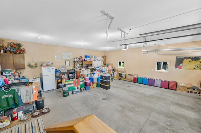 76 Meceola Ct, Hersey, MI 49639 - garage with a garage door opener and freestanding refrigerator