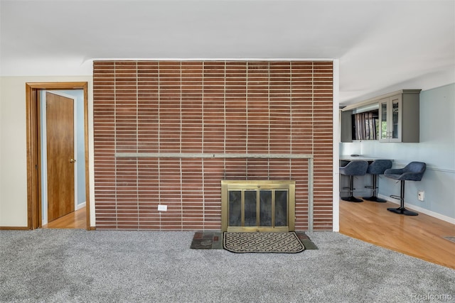 1024 London Ave, Lincoln Park, MI 48146 - unfurnished living room featuring a tile fireplace, carpet floors, and wood finished floors