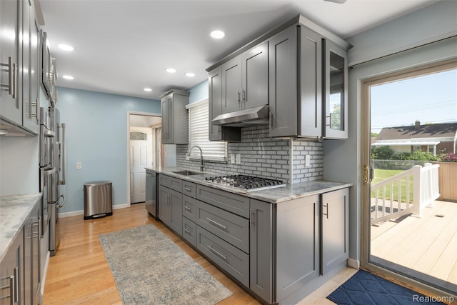 1024 London Ave, Lincoln Park, MI 48146 - kitchen featuring appliances with stainless steel finishes, gray cabinetry, decorative backsplash, light wood finished floors, and light stone counters
