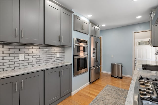 1024 London Ave, Lincoln Park, MI 48146 - kitchen featuring appliances with stainless steel finishes, gray cabinetry, tasteful backsplash, light wood finished floors, and recessed lighting