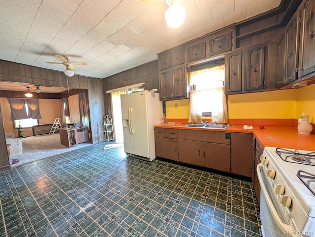 1402 Allen St, Burton, MI 48529 - kitchen with white appliances, a ceiling fan, dark flooring, wooden walls, and light countertops