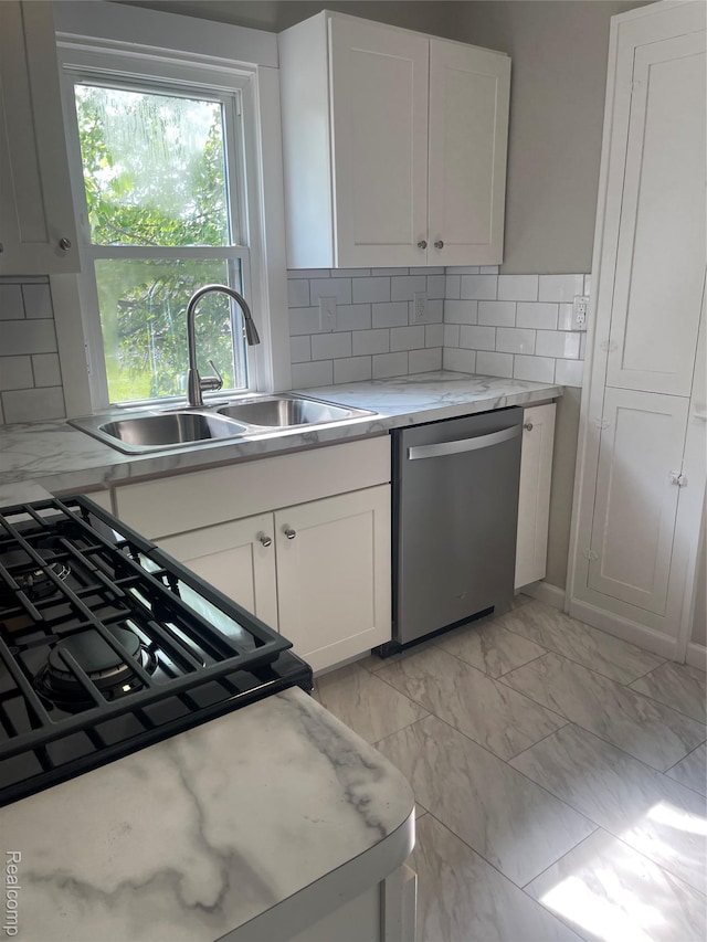 160 Emmons Blvd, Wyandotte, MI 48192 - kitchen with stainless steel dishwasher, light marble finish flooring, white cabinetry, decorative backsplash, and black gas stove