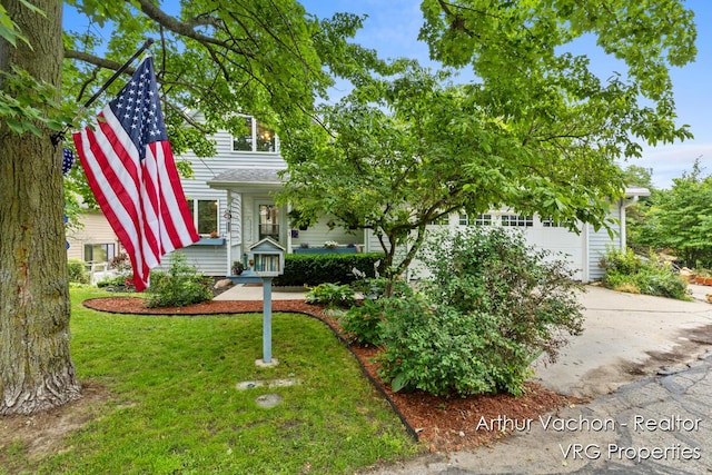 331 Conkey Dr, Michigan, MI 48834 - obstructed view of property featuring a front lawn, concrete driveway, and an attached garage