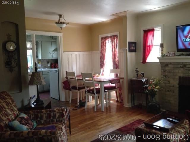 1431 Denies St, Burton, MI 48509 - dining room featuring wood finished floors, a fireplace, and a wainscoted wall