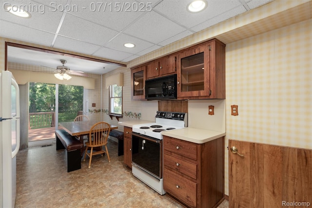 20225 Shady Lane Ave, Saint Clair Shores, MI 48080 - kitchen featuring white appliances, light countertops, brown cabinetry, wainscoting, and a paneled ceiling