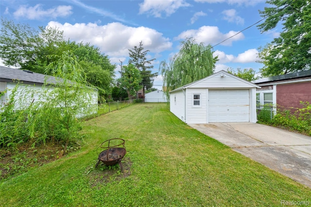18379 Hazelwood St, Roseville, MI 48066 - view of yard featuring an outdoor fire pit, an outbuilding, driveway, and a garage
