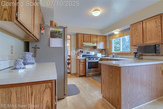 21905 Roxbury Dr, Novi, MI 48374 - kitchen with stainless steel appliances, under cabinet range hood, light wood-style flooring, and light countertops