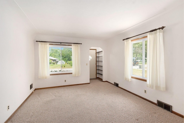 2329 Moon St, Muskegon, MI 49441 - carpeted spare room featuring arched walkways and baseboards