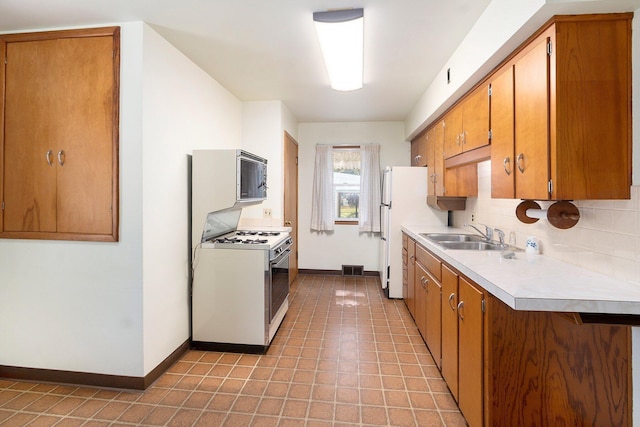 2329 Moon St, Muskegon, MI 49441 - kitchen featuring gas range gas stove, light countertops, brown cabinetry, and tasteful backsplash