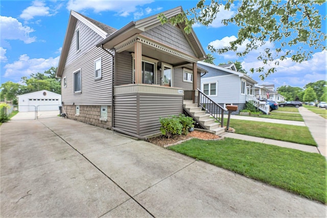 23926 Elmira St, Saint Clair Shores, MI 48082 - view of front facade featuring an outdoor structure, a detached garage, a porch, and a front lawn