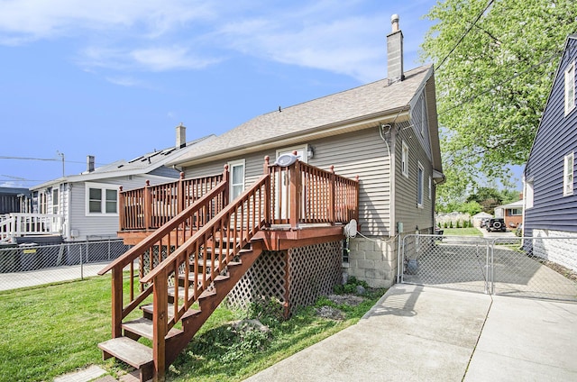 23926 Elmira St, Saint Clair Shores, MI 48082 - back of house with a chimney, a gate, a deck, a shingled roof, and concrete driveway