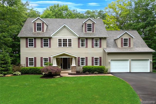 12151 Vergennes St, Lowell, MI 49331 - colonial-style house featuring asphalt driveway, a front yard, a shingled roof, and an attached garage