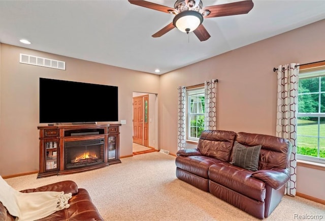 12151 Vergennes St, Lowell, MI 49331 - carpeted living room featuring plenty of natural light, a glass covered fireplace, a ceiling fan, and recessed lighting