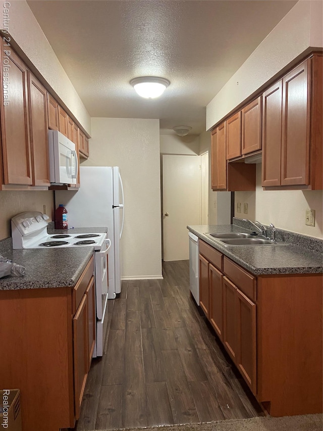 24857 Auburn Ln, Southfield, MI 48033 - kitchen featuring white appliances, dark countertops, dark wood finished floors, a textured ceiling, and brown cabinetry
