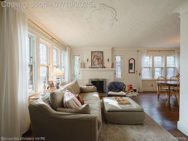 4858 Yorkshire Rd, Detroit, MI 48224 - living room with a textured ceiling, dark wood-style flooring, and a brick fireplace