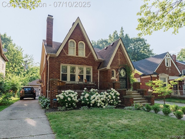 4858 Yorkshire Rd, Detroit, MI 48224 - tudor-style house featuring brick siding, a front lawn, and a chimney