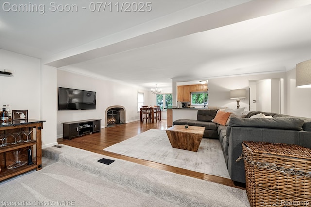 27461 Goldengate Dr W, Lathrup Village, MI 48076 - living room featuring a chandelier, wood finished floors, and a warm lit fireplace