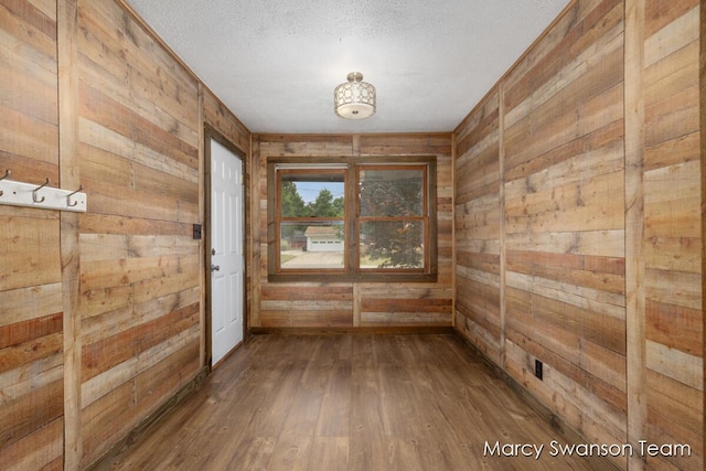 4172 Ranchero Dr, Dorr, MI 49323 - unfurnished room featuring wood walls, hardwood / wood-style flooring, and a textured ceiling