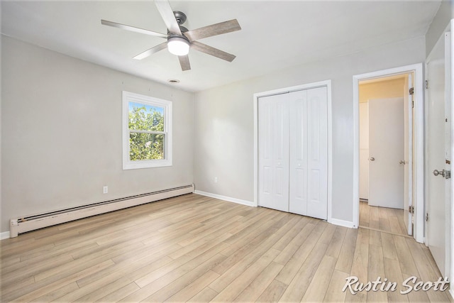 2953-2955 Okemos Dr SE, Grand Rapids, MI 49546 - unfurnished bedroom featuring a baseboard radiator, a closet, light wood-style floors, and a ceiling fan