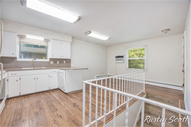 2953-2955 Okemos Dr SE, Grand Rapids, MI 49546 - kitchen featuring a baseboard radiator, light wood finished floors, white dishwasher, white cabinets, and backsplash