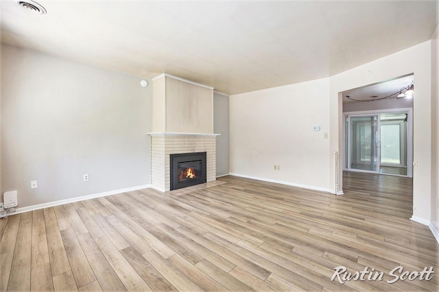 2953-2955 Okemos Dr SE, Grand Rapids, MI 49546 - unfurnished living room featuring light wood-type flooring and a fireplace