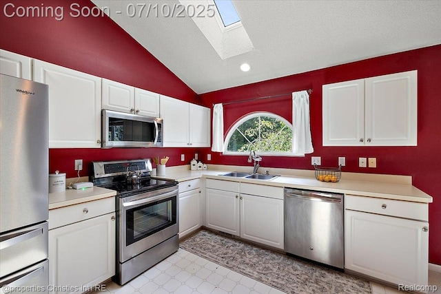 6873 Fox Ln, Waterford, MI 48327 - kitchen with stainless steel appliances, a skylight, white cabinetry, lofted ceiling, and light countertops