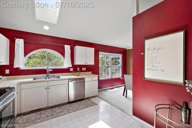 6873 Fox Ln, Waterford, MI 48327 - kitchen featuring stainless steel appliances, white cabinetry, light countertops, a skylight, and recessed lighting