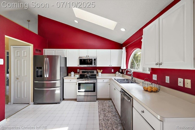 6873 Fox Ln, Waterford, MI 48327 - kitchen featuring appliances with stainless steel finishes, a skylight, white cabinetry, light flooring, and light countertops